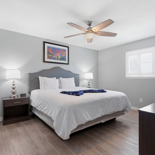 Unit 303 – Airy primary bedroom w/ a king bed & soft natural light.