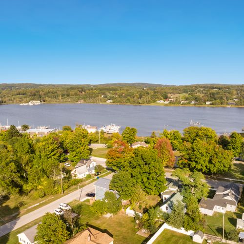 EXTERIOR: Aerial view on a beautiful, sunny day of the property and the gorgeous Betsie Bay
