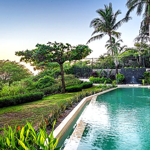 Community pool at sunset with ocean glimpse