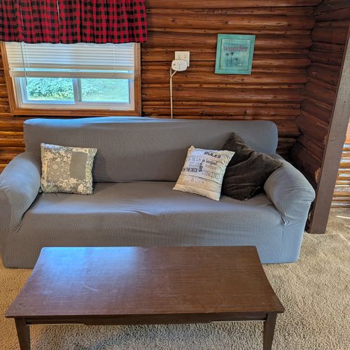 LIVING ROOM:  Large and comfy living room with a sofa, comfy chair, 2 futons, a coffee table, streaming television, and window A/C unit.