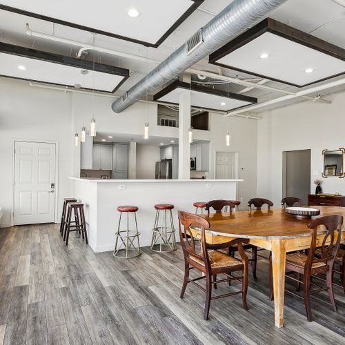 Open living & dining area w/ bar-style seating & exposed-beam ceiling.