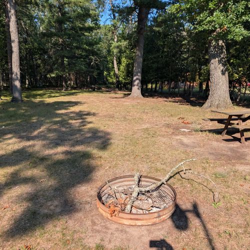 EXTERIOR:  The large backyard showing the bonfire ring and picnic table.