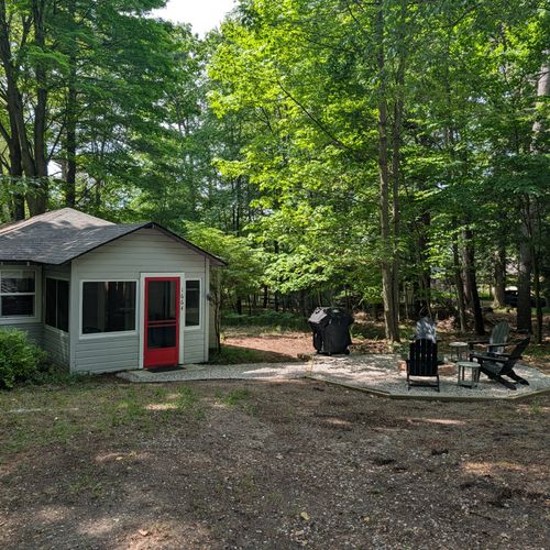 EXTERIOR: The view of the backside of the property. The cute cabin is on the left connected the luxurious firepit and grill on the right by a beautiful pea gravel path