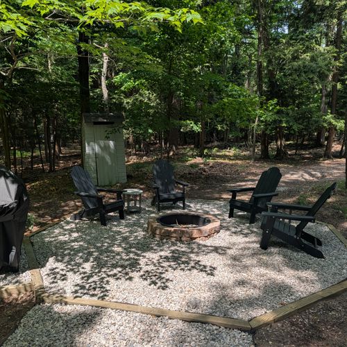 OVERVIEW: The gorgeous firepit with chairs around for seating and a grill for guest use, aggregated pea gravel makes up the ground of the beautiful firepit area. Perfect for gathering around the fire!