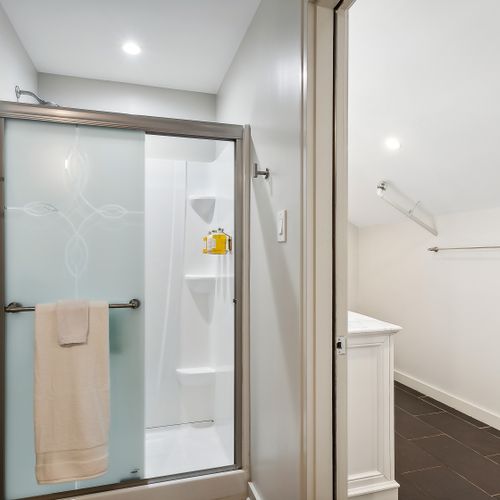 Glass-door shower w/ handy shelving.
