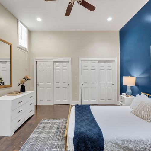 Navy bedroom with dual closets and a dresser