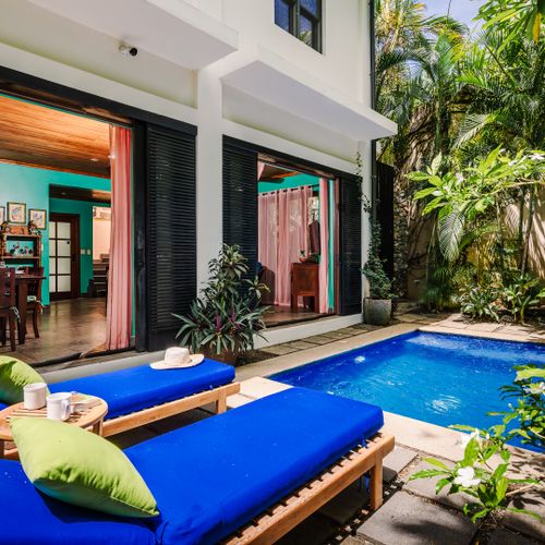 Private pool surrounded by tropical garden at this Playa Langosta vacation rental. Terrace with comfortable loungers, lush landscaping, and outdoor living space. Perfect for sunbathing, relaxation, and coastal luxury inside a gated community.