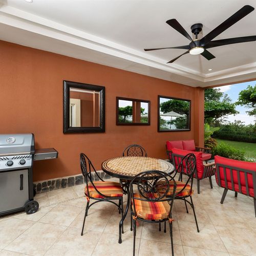 Private balcony with outdoor dining table and BBQ grill at luxury Playa Langosta condo in Tamarindo, Costa Rica. Steps from the pool and beach, perfect for al fresco meals, sunset cocktails, and entertaining family and friends together.