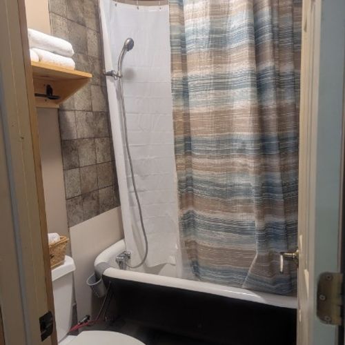 BATHROOM:  Includes a tub, shower, and toilet.  Note that there is no sink, vanity, nor mirror in the bathroom.