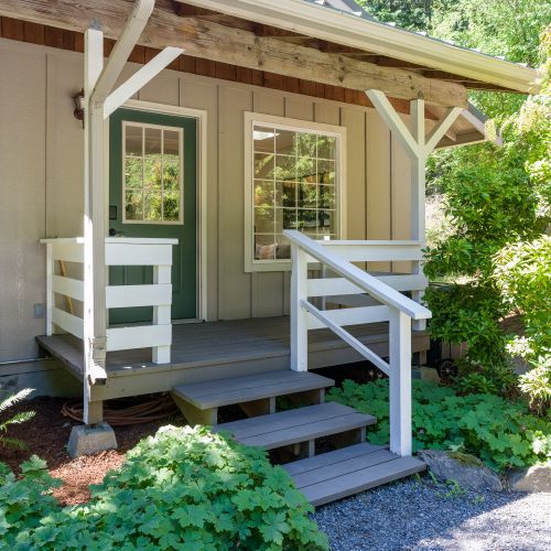 A charming covered porch welcomes you to this peaceful woodland retreat.