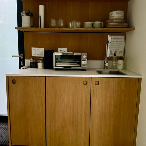A tidy kitchenette stocked with coffee, a toaster oven, and the everyday essentials.