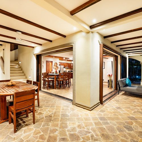 Covered stone patio with archways linking kitchen, dining and pool deck at Casa Blue Lagoon beachfront villa, Tamarindo, Costa Rica.