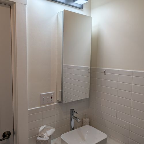 BATHROOM: The cute full bathroom's sink and openable mirror for storage