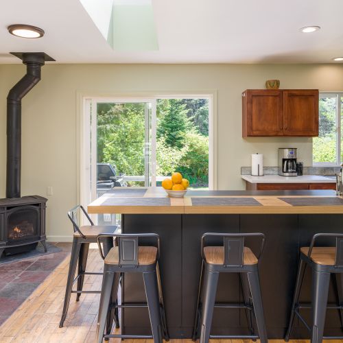 Open-concept kitchen with breakfast bar, cozy fireplace, and easy access to the outdoor patio