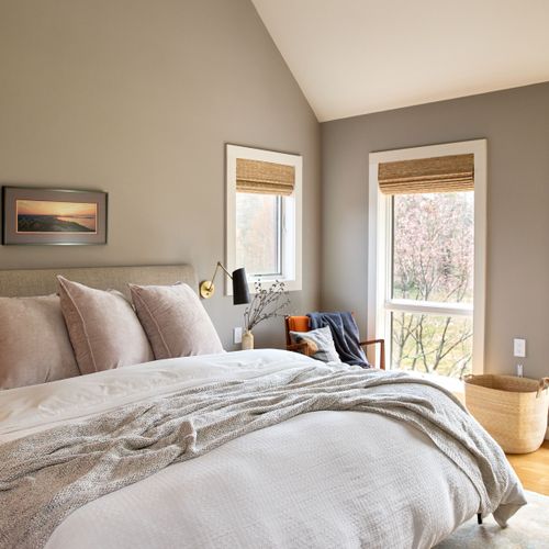 The primary bedroom in the main house, with views of the pool and private meadow.