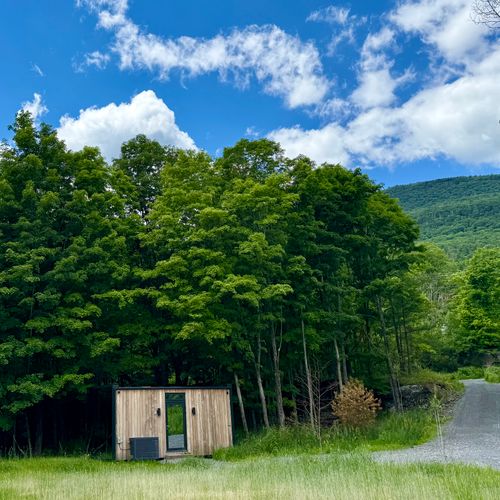 The guest house at the meadow's edge, a gravel drive winding toward the Catskills.