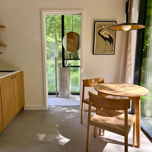 Sunlit dining nook with a round oak table and a signature heron print.
