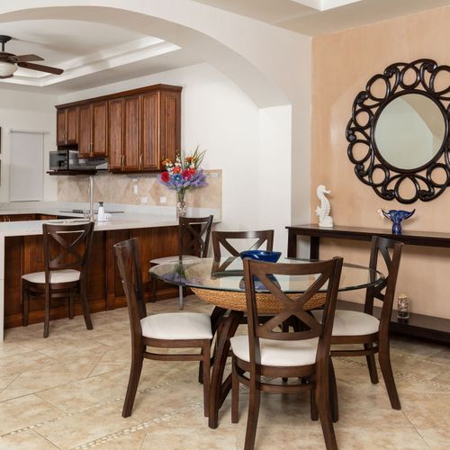 Open concept dining area and gourmet kitchen at a luxury Playa Langosta condo in Tamarindo, Costa Rica featuring breakfast bar, natural light, spacious interiors, and elegant coastal design ideal for family vacations, entertaining and remote work.