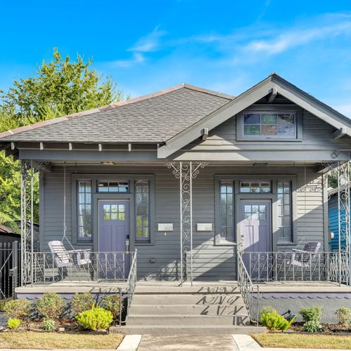 Charming craftsman-style home w/ a covered front porch & leafy landscaping