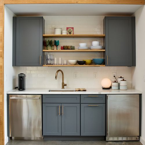 The pool house kitchenette features a dishwasher and mini fridge with ice maker, perfect for easy outdoor entertaining.