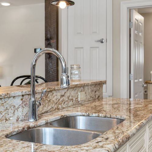 Polished faucet over rich granite