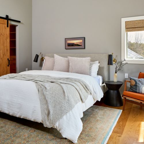 Upstairs in the main house, the primary bedroom features a king bed, soaring ceilings, walk-in closet and ensuite bath.