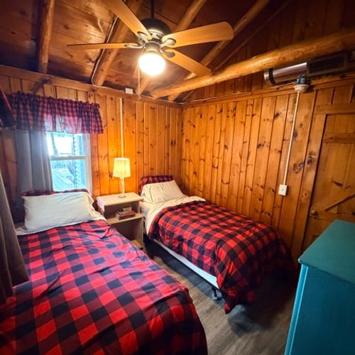 BEDROOM #3:  Features two single beds, a nightstand with a lamp, ceiling fan, and a dresser.