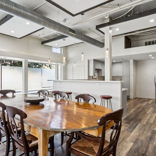 Airy dining area w/ wood table, seating for a crowd & natural light.