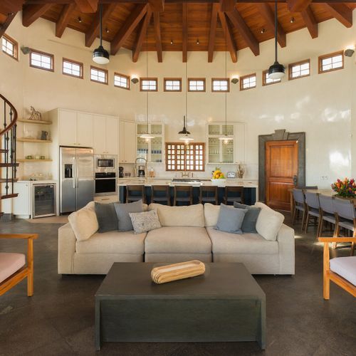 Open-concept great room - vaulted exposed-beam ceiling, dining for 8+, full chef kitchen, wrought-iron spiral stair.