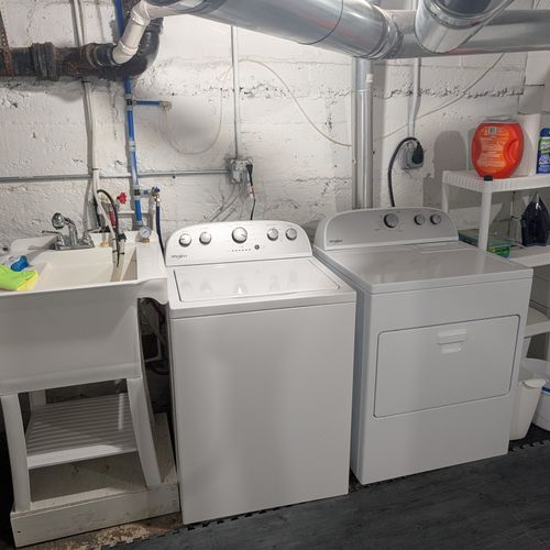 LAUNDRY ROOM (BASEMENT):  Large laundry room in the basement with a top load washer and a dryer.