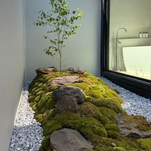 A serene moss-and-stone garden brings nature right up to the bath.