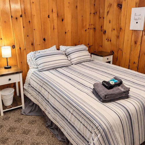 BEDROOM #1:   Features a queen-size bed, nightstands, lamp, dresser, closet, and chair.
