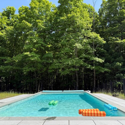 Cool off in the private pool, tucked against a backdrop of lush summer forest.