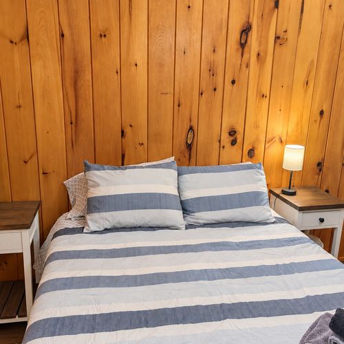 BEDROOM #2:   Features a queen-size bed, nightstands, lamp, dresser, closet, and chair.
