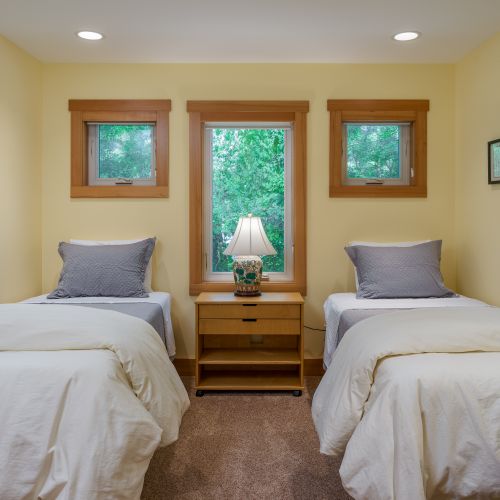 Perfect for kids or friends, this cozy bedroom offers two comfortable twin beds, soft linens, and peaceful garden views for a restful night's sleep.