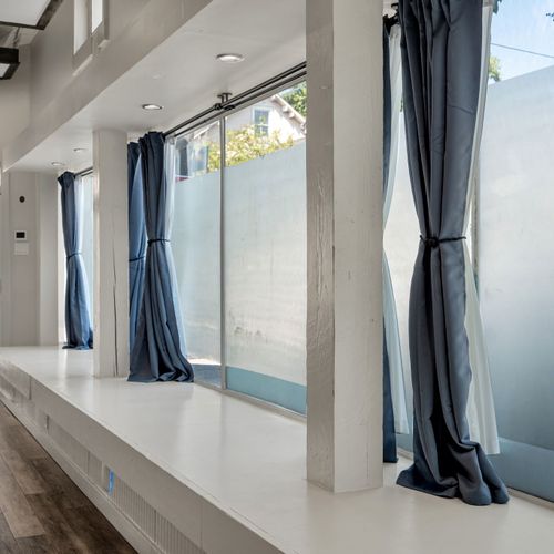 Floor-to-ceiling windows with dramatic blue drapes