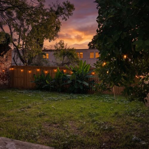 Spacious backyard w/ lush green lawn — plenty of room to relax or play outside.