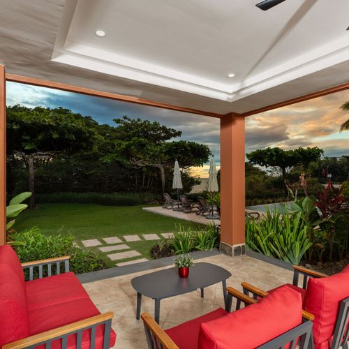 Breathtaking sunset views from private balcony at luxury Playa Langosta condo in Tamarindo, Costa Rica. Golden sky over Pacific Ocean, tropical gardens below, and shimmering pool. Perfect for romantic evenings and peaceful relaxation.