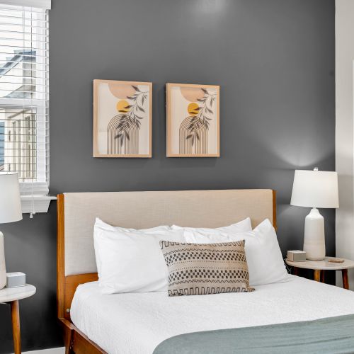Botanical prints above a plush upholstered bed