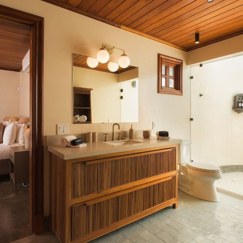 Ensuite bath with a curved glass walk-in shower opening straight to the bedroom.