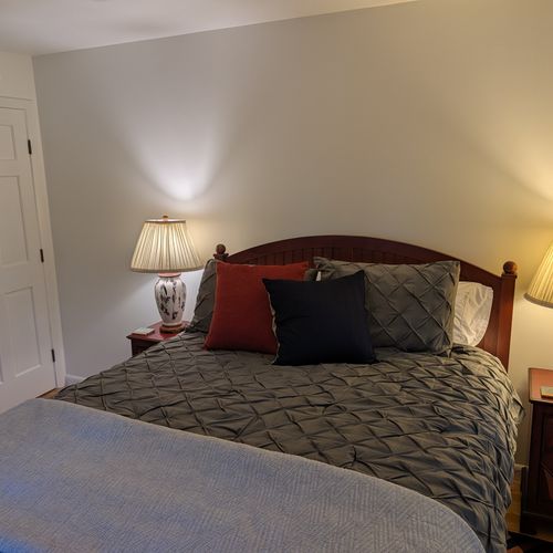 BEDROOM #2 (SECOND FLOOR):  Features a queen-size bed, nightstands, lamps, ceiling fan, dresser, mirror, and closet.