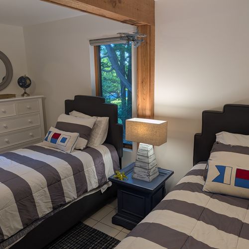 BEDROOM #4 (SECOND FLOOR):  Features 2 twin size beds, a dresser, mirror, nightstand, lamp, ceiling fan, and a clothes rack.