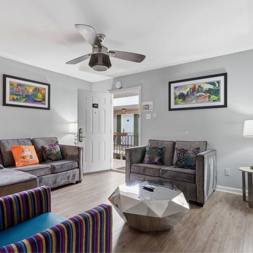Welcoming living room w/ ceiling fan & a clear sightline to the entryway.