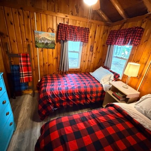 BEDROOM #3:  Features two single beds, a nightstand with a lamp, ceiling fan, and a dresser.