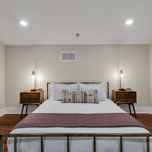 Tufted gray headboard with walnut nightstands