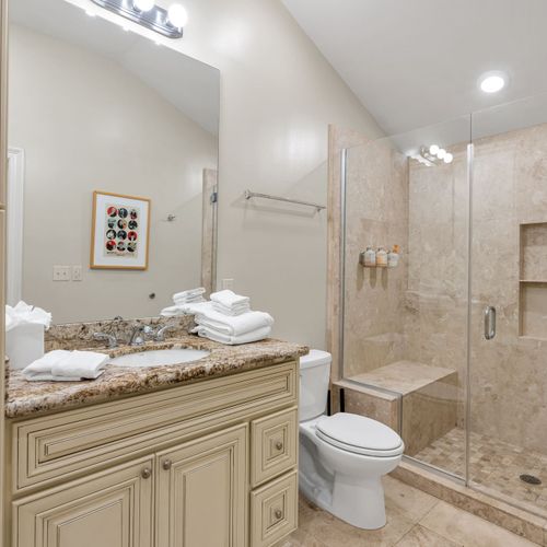 Framed art and granite in a sparkling bath