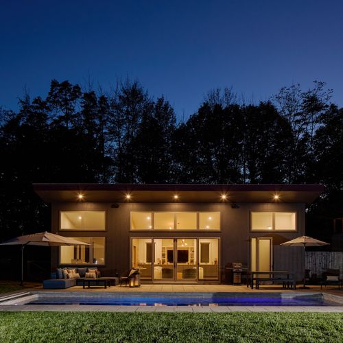 A shot of the pool house at night, which looks out onto five private acres.