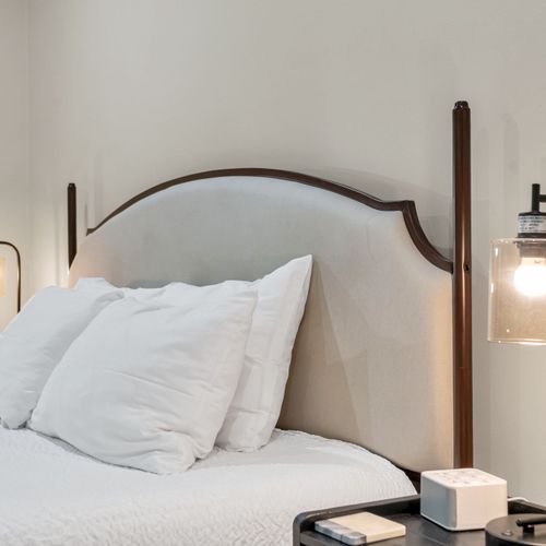 Curved upholstered headboard with sconce lighting