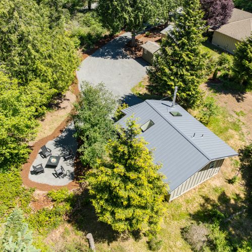 Aerial view showcasing the private cabin, fire pit lounge, and peaceful forest surroundings.