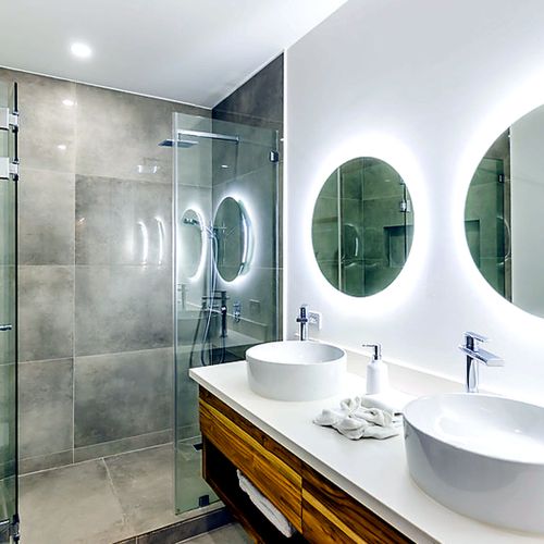 En-suite primary bathroom with a double vessel-sink vanity and spa like shower.